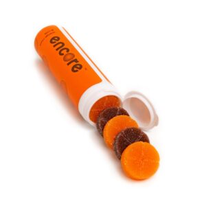 An image of Encore Edibles 600mg THC Orange Soda & Cola Gummies in their tube packaging with some stacked in front of it to showcase the gummies