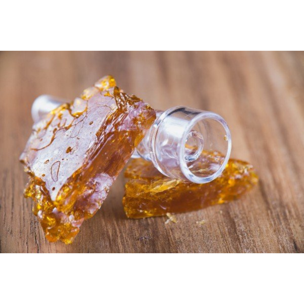 An image of two pieces of shatter with a dab part showing how to smoke shatter